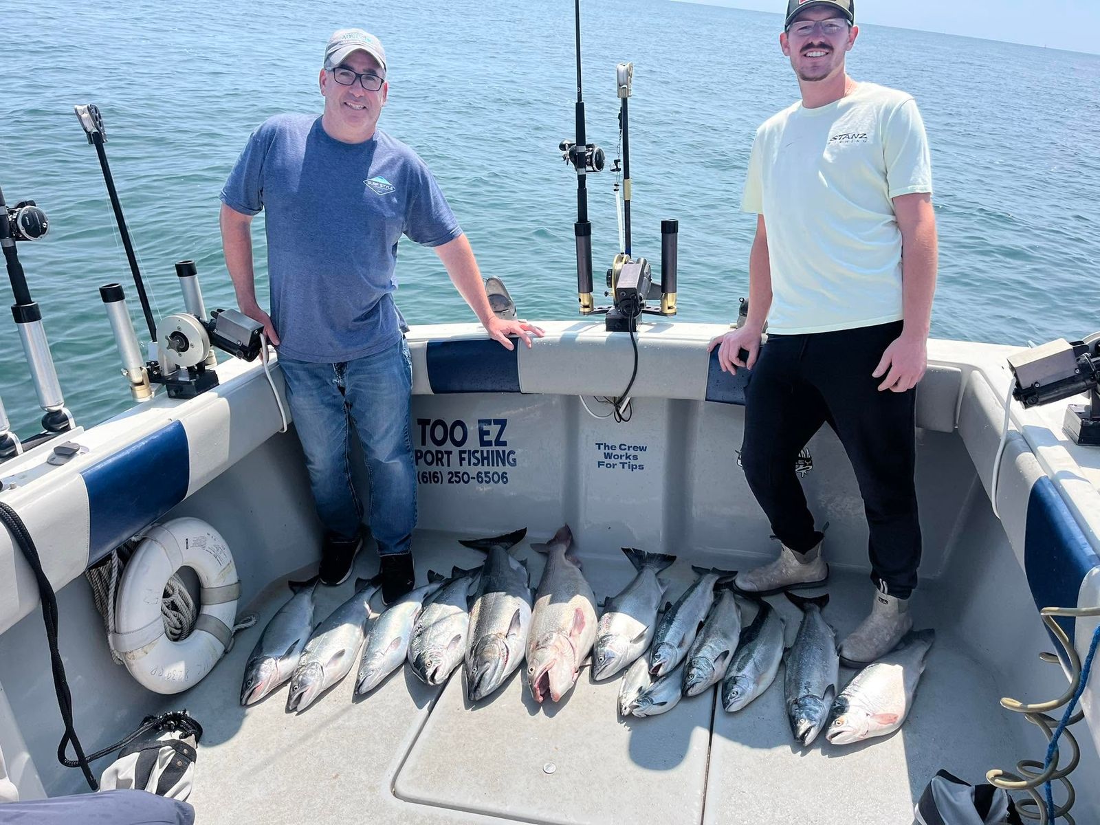 Two anglers hold up their Lake Michigan catch aboard the Too Ez Sportfishing charter boat