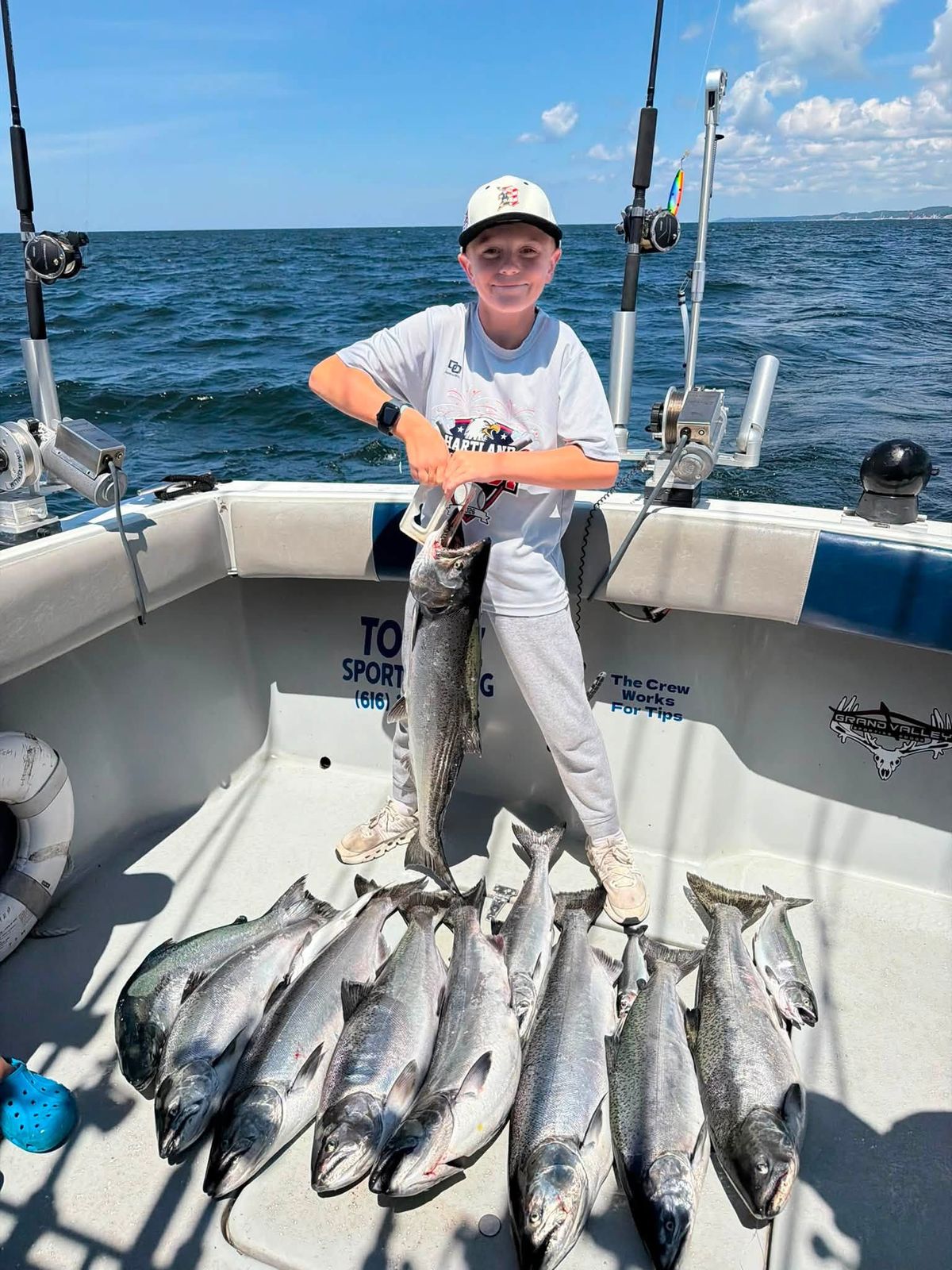 A charter guest displays a large catch of lake fish aboard the boat on Lake Michigan