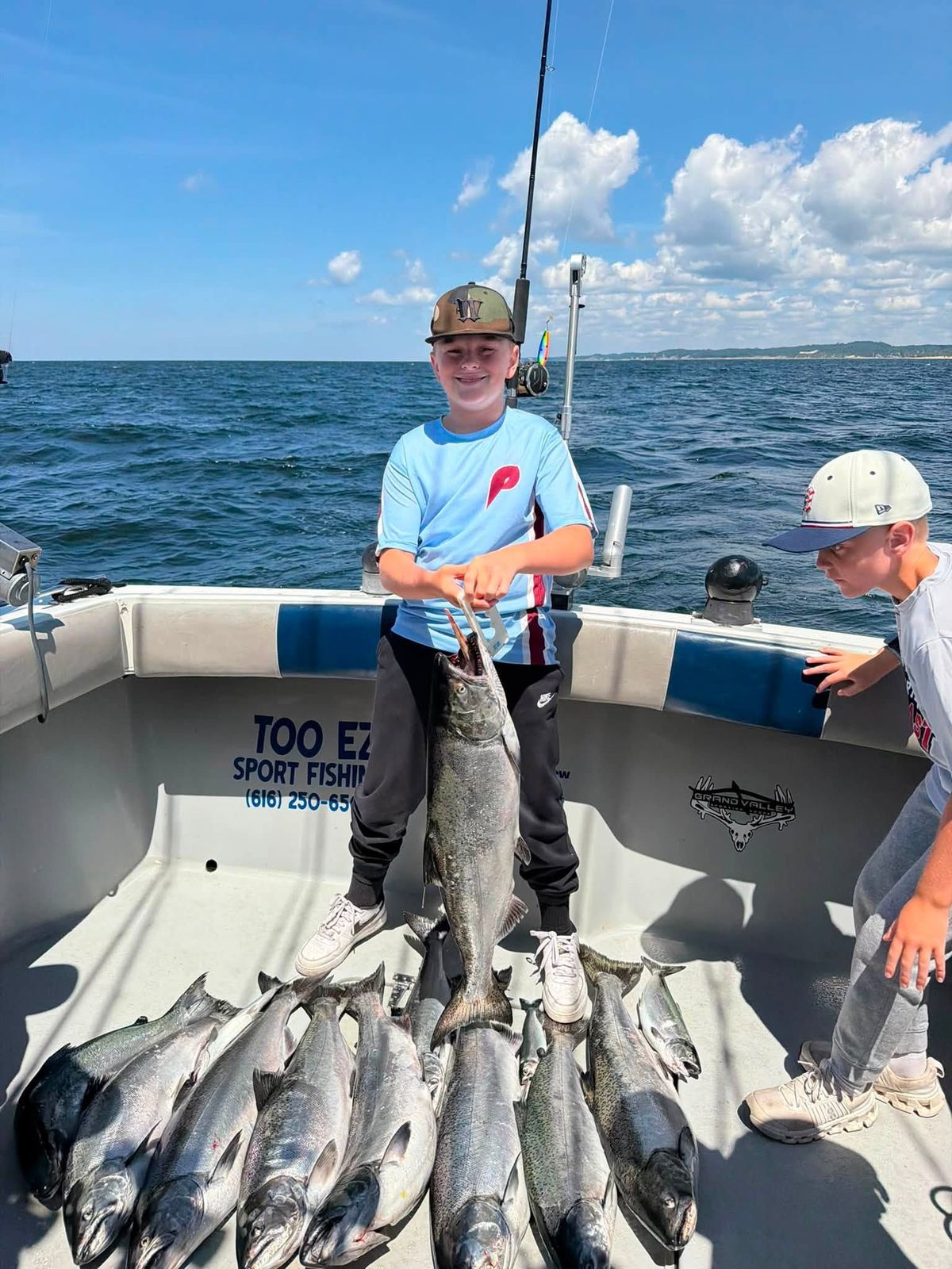 A guest proudly displays a large catch of fish aboard the Too Ez charter boat