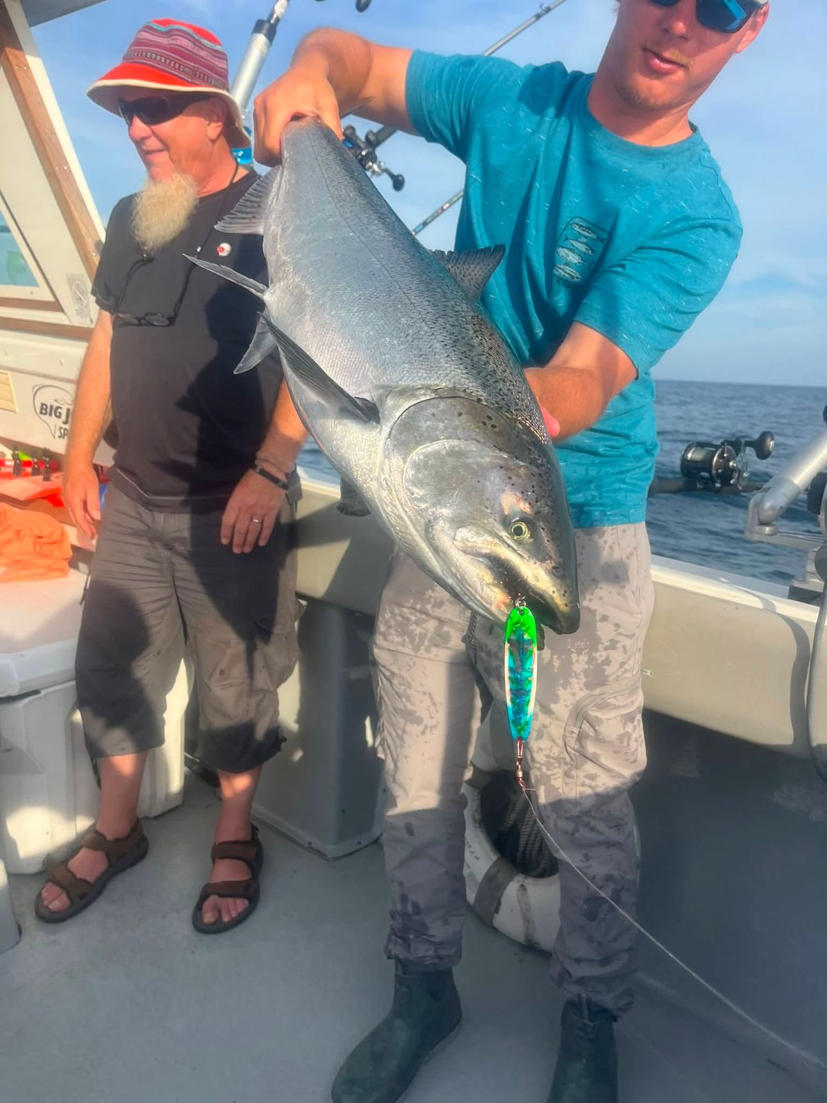 Two anglers display a large lake trout on Lake Michigan
