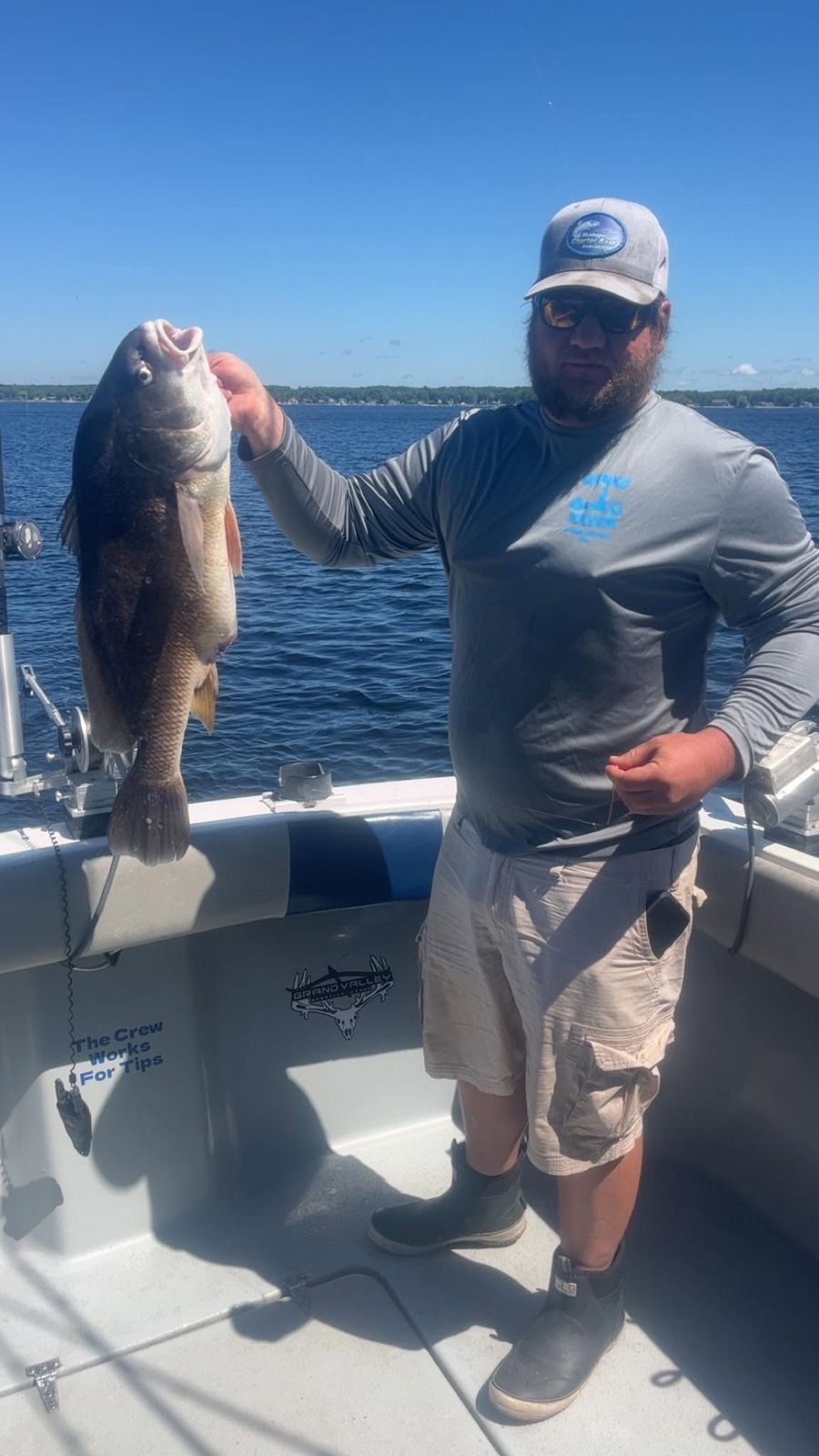 Captain Anthony Sova holds up a large freshwater fish aboard the boat