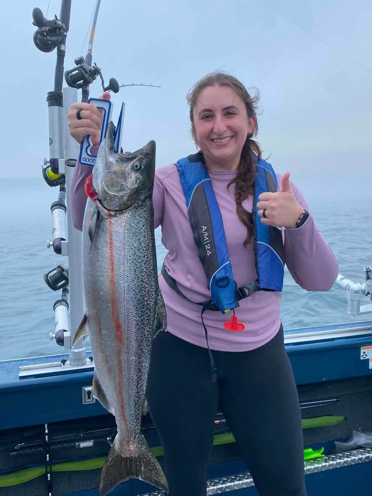 An angler holds up a large lake trout caught on the charter