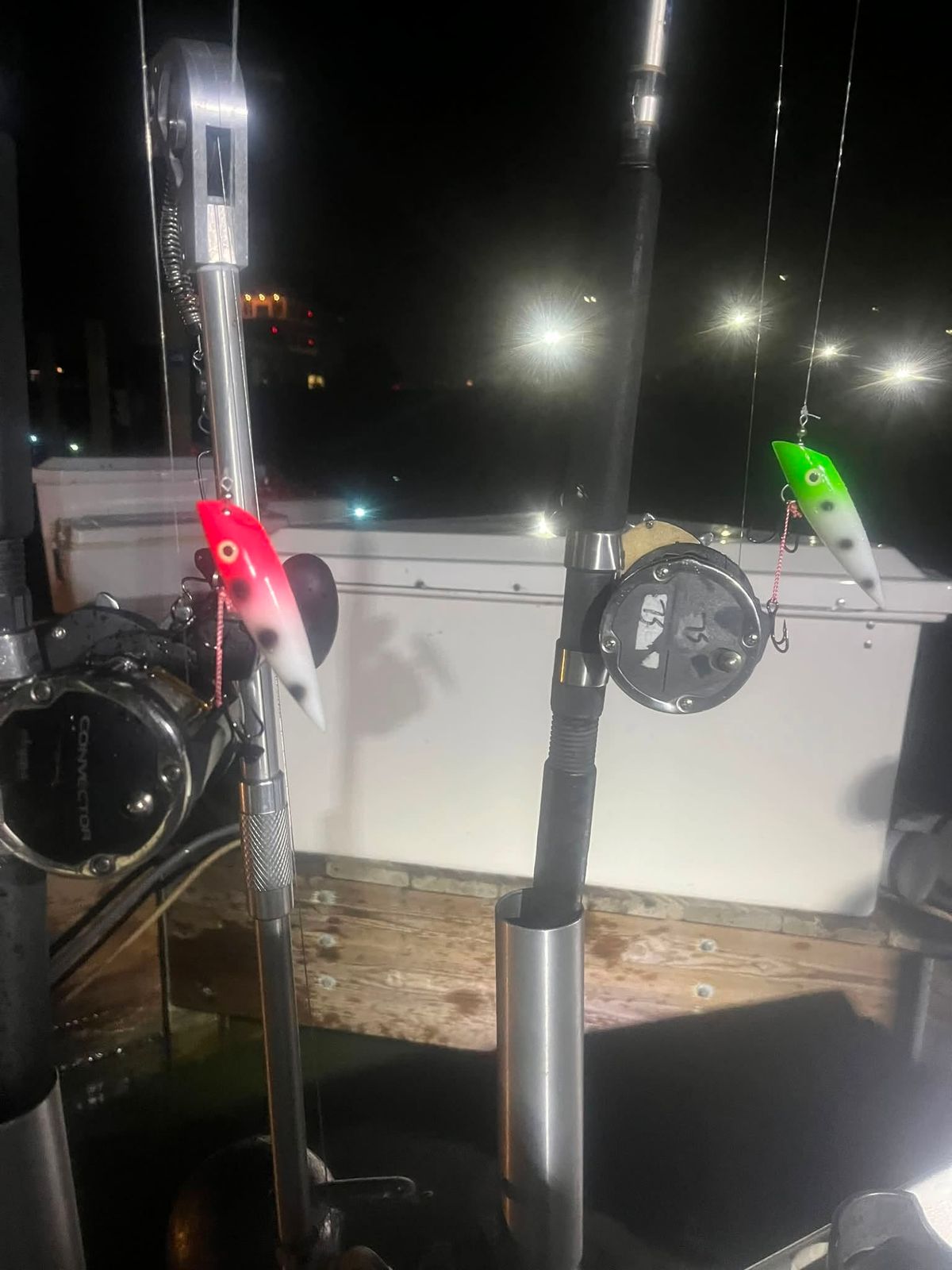 Fishing rods with lures rigged and ready on the charter boat at night, docked at the Muskegon port