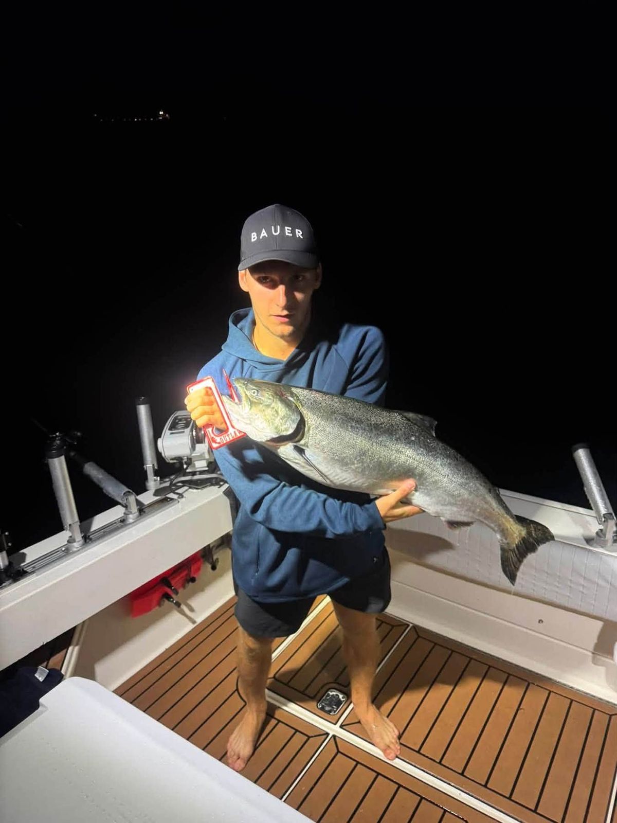 Captain Anthony Sova holds a large lake trout aboard the charter boat