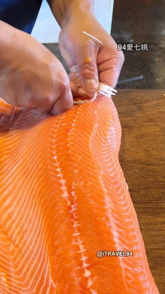 Captain Anthony Sova's hands showing a fresh salmon fillet aboard the charter