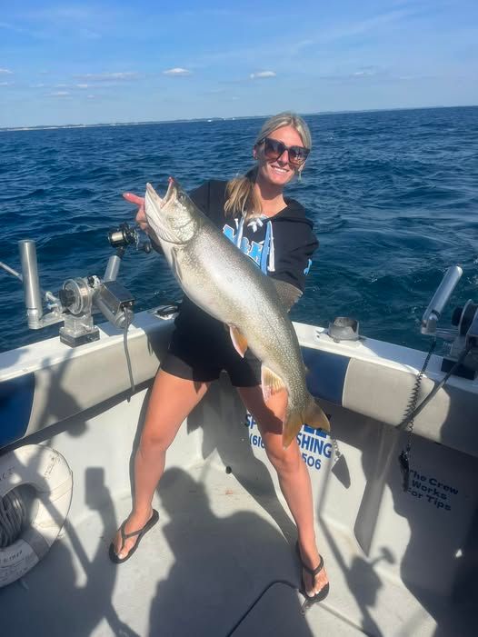 A satisfied angler displays a large caught fish aboard the charter boat