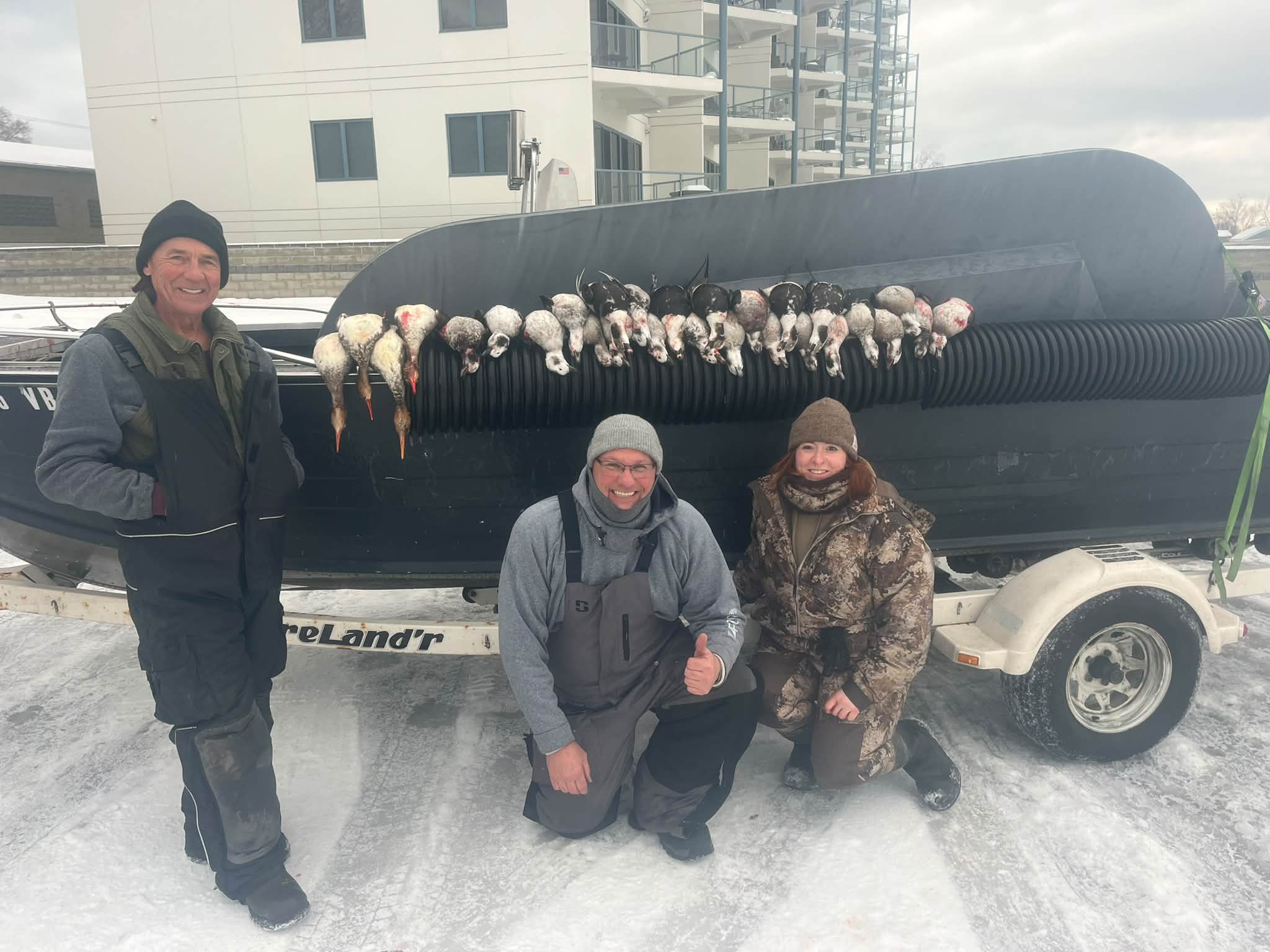 Three successful anglers display their large catch of walleye and perch on a fish transport tank at Too Ez Sportfishing.